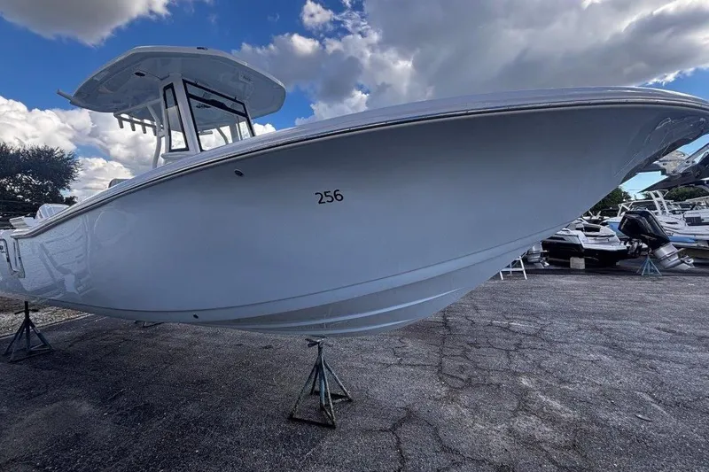 Slide: The Image of 2026 Tidewater 256 CC Adventure boat on display under cloudy sky. - 5