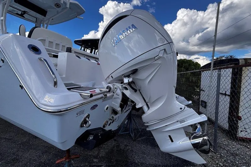 Slide: The Image of 2026 Tidewater 256 CC Adventure boat with Yamaha outboard motor, parked outdoors. - 8