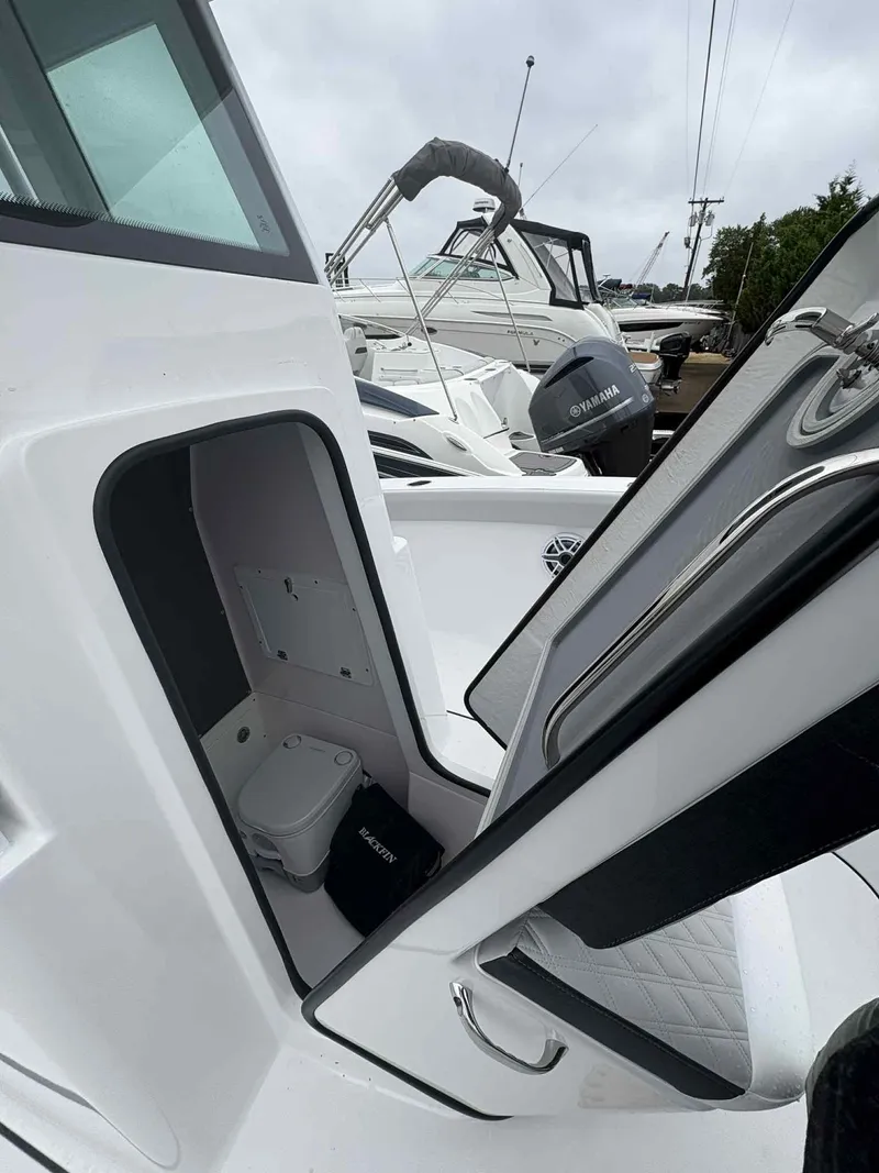Slide: The Image of 2026 Blackfin 242HB boat interior with open storage compartment and visible toilet. - 14