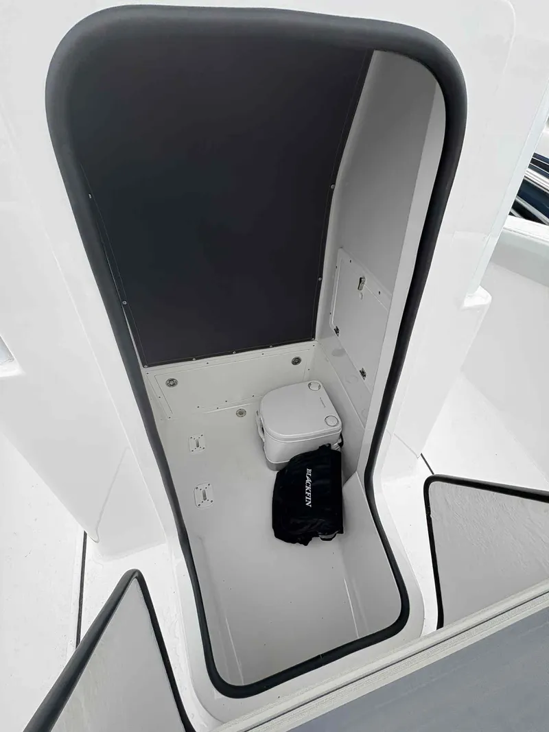 Slide: The Image of 2026 Blackfin 242HB boat interior with compact toilet and storage area. - 15
