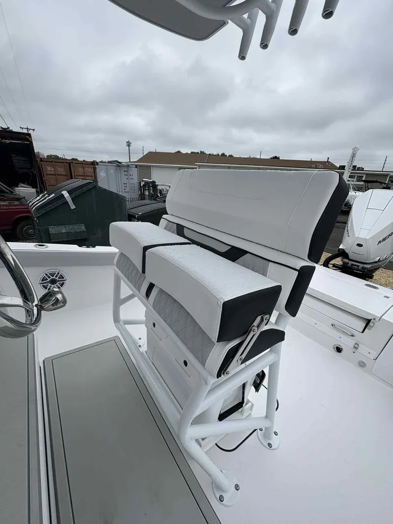 Slide: The Image of 2026 Blackfin 242HB boat seating with white and gray upholstery, outdoor setting. - 16