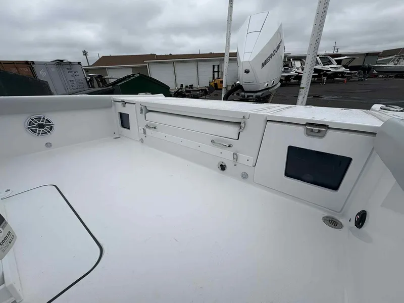 Slide: The Image of 2026 Blackfin 242HB boat deck with storage compartments and Mercury outboard motor. - 19