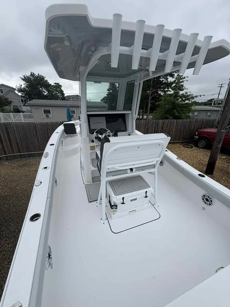 Slide: The Image of 2026 Blackfin 242HB boat with center console and seating, parked outdoors. - 6