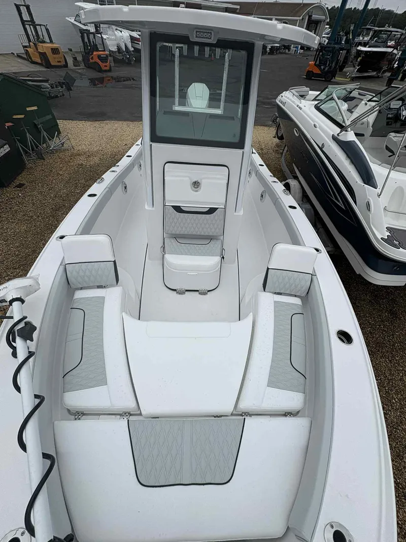 Slide: The Image of 2026 Blackfin 242HB boat interior with white seating and console, docked at a marina. - 7