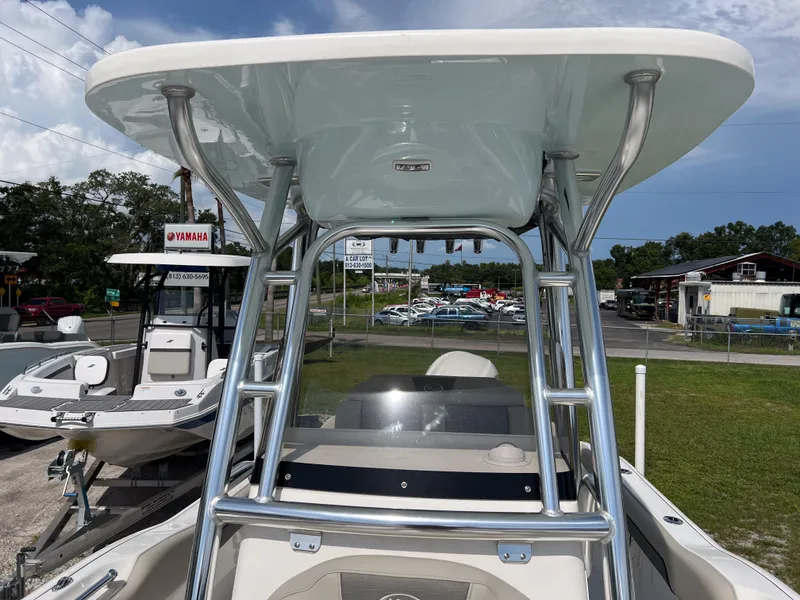 Slide: The Image of 2025 Key West 239 FS boat with T-top, displayed outdoors at a dealership. - 14