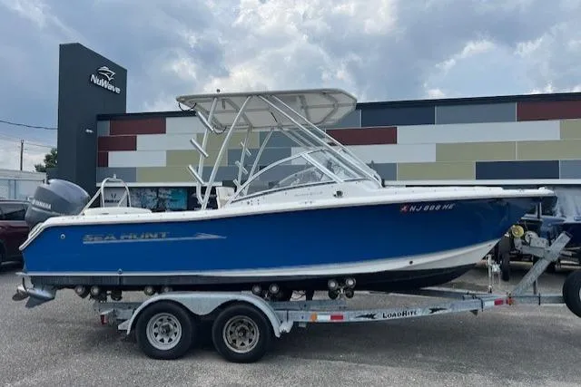 Slide: The Image of 2013 Sea Hunt Escape 211 LE boat on trailer, parked outside Nuwave building. - 0