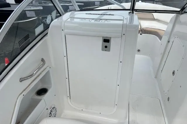 Slide: The Image of 2013 Sea Hunt Escape 211 LE boat interior with white seating and storage compartment. - 12