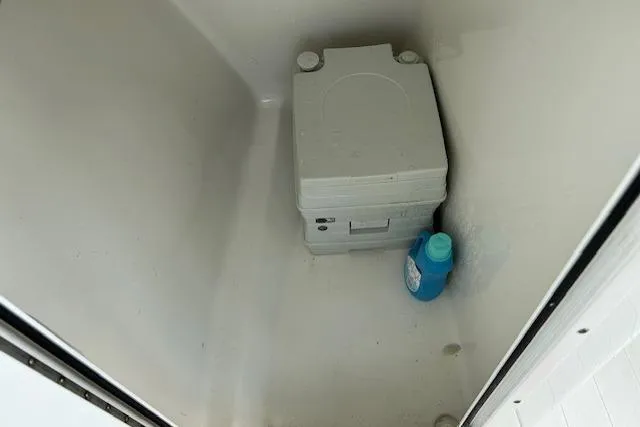 Slide: The Image of Portable toilet and cleaning product inside 2013 Sea Hunt Escape 211 LE boat compartment. - 13