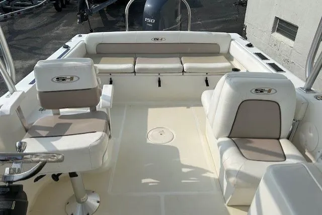 Slide: The Image of 2013 Sea Hunt Escape 211 LE boat interior with cushioned seating and steering console. - 16