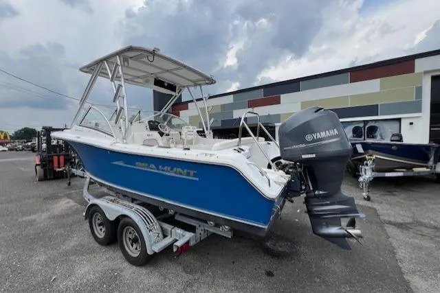 Slide: The Image of 2013 Sea Hunt Escape 211 LE boat with Yamaha motor on a trailer, parked outdoors. - 3