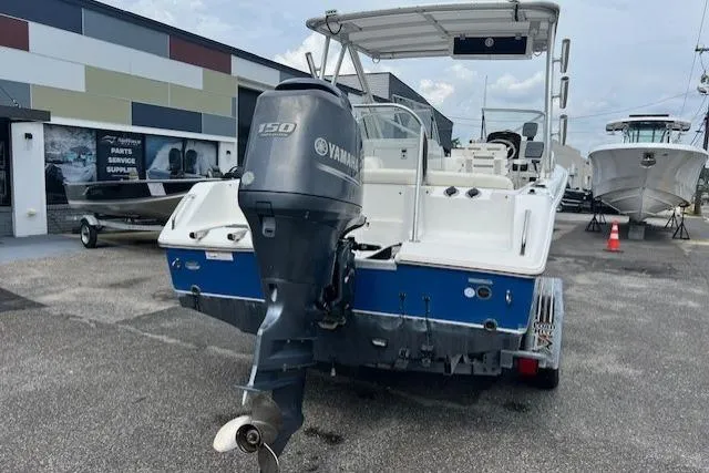 Slide: The Image of 2013 Sea Hunt Escape 211 LE boat with Yamaha 150 outboard motor, parked outdoors. - 4