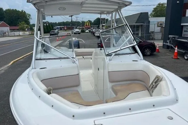 Slide: The Image of 2013 Sea Hunt Escape 211 LE boat with spacious seating, parked in a lot. - 7