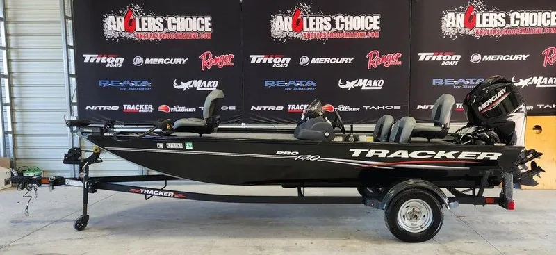 The Image of 2024 Tracker Pro 170 boat on trailer in showroom with Anglers Choice backdrop. - 1