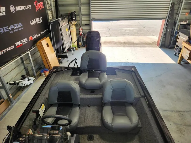 Slide: The Image of 2024 Tracker Pro 170 boat interior with gray seating in a garage setting. - 7