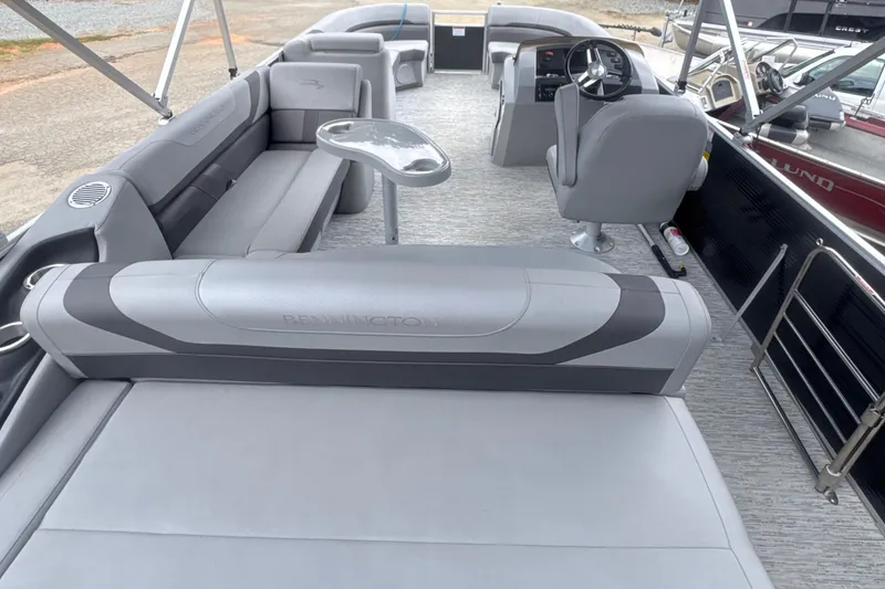 Slide: The Image of 2023 Bennington 22SX Swingback pontoon boat interior with gray seating and steering console. - 1