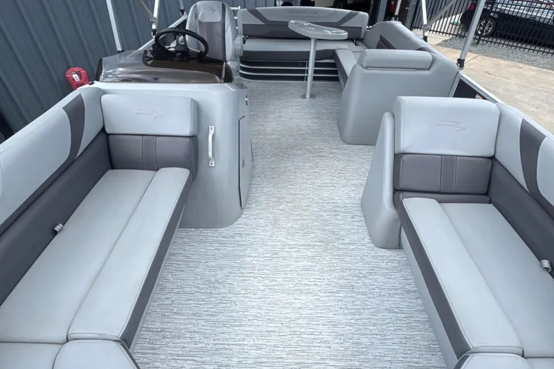 Slide: The Image of 2023 Bennington 22SX SWINGBACK pontoon boat interior with gray seating and steering console. - 13