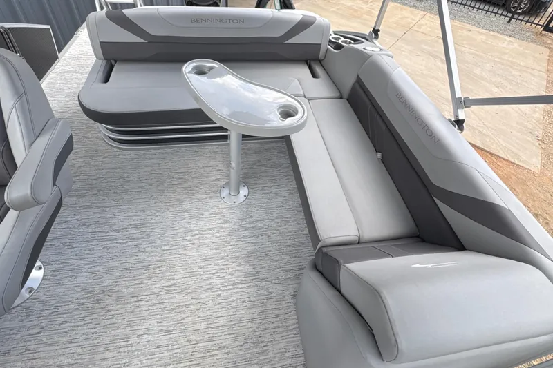 Slide: The Image of 2023 Bennington 22SX Swingback boat interior with gray seating and table. - 21