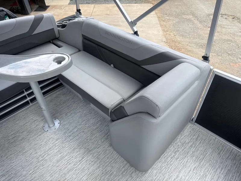Slide: The Image of 2023 Bennington 22SX SWINGBACK boat interior with gray seating and table. - 23