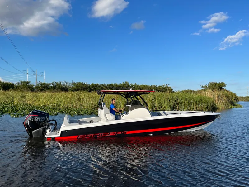 The Image of 2023 Concept 32' CC boat on a calm river under a clear blue sky. - 0