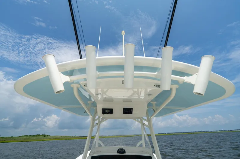 Slide: The Image of 2019 Regulator 34 Center Console boat with rod holders, under a clear blue sky. - 14