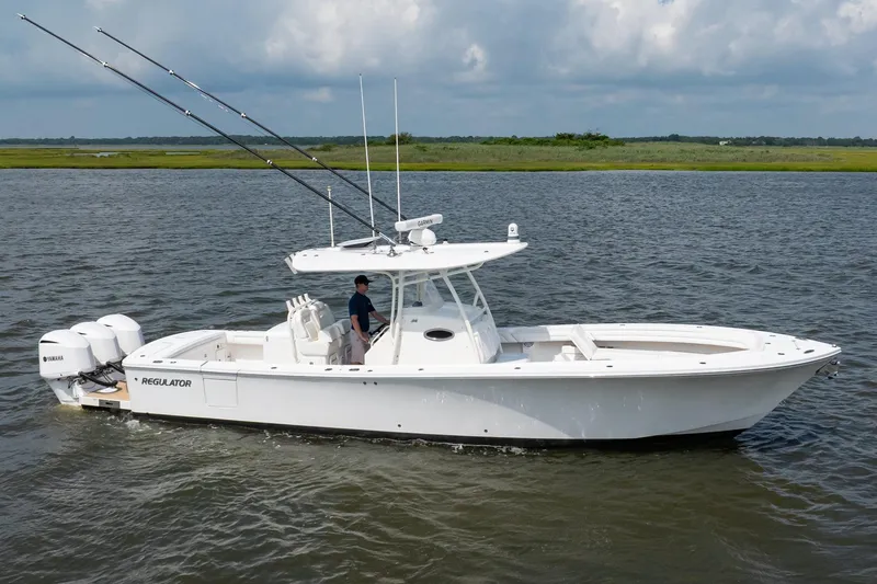 Slide: The Image of 2019 Regulator 34 Center Console boat on water with fishing rods and Yamaha engines. - 4