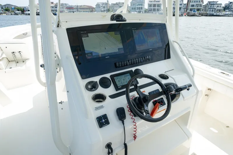 Slide: The Image of 2019 Regulator 34 Center Console boat dashboard with navigation screens and steering wheel. - 9