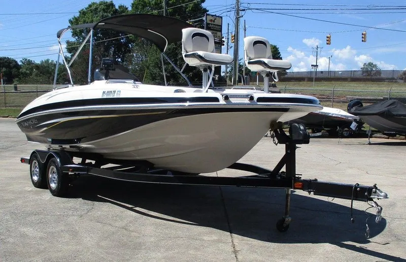 Slide: The Image of 2011 Tahoe 195 boat on trailer, parked outdoors, featuring dual seats and canopy. - 5