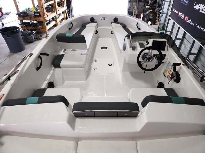Slide: The Image of 2025 Tahoe T18 boat interior with seating and steering wheel in a garage setting. - 10