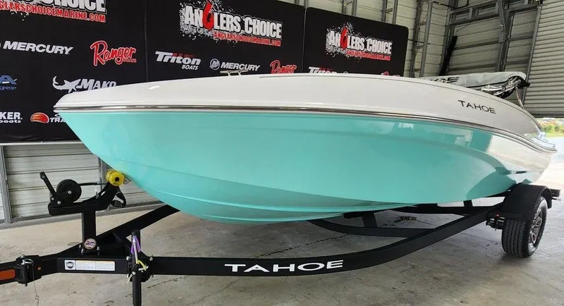 Slide: The Image of 2025 Tahoe T18 boat on trailer in showroom, featuring sleek design and turquoise hull. - 5