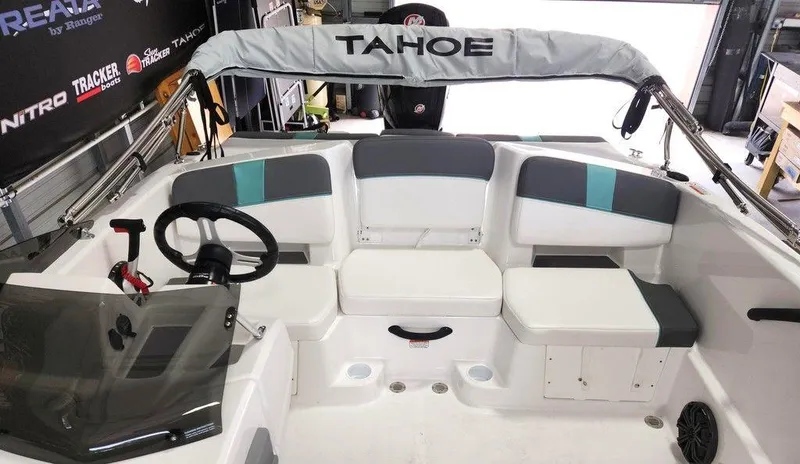 Slide: The Image of 2025 Tahoe T18 boat interior with seating and steering wheel in a showroom. - 8