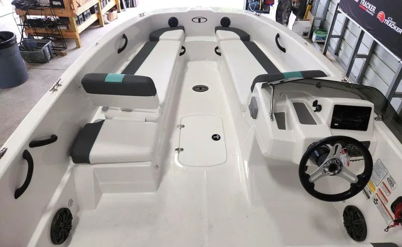 Slide: The Image of 2025 Tahoe T18 boat interior with seating, steering wheel, and storage compartments in a garage setting. - 9