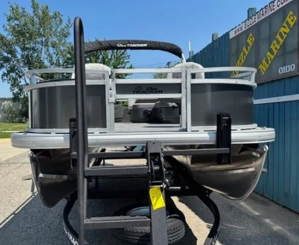 Slide: The Image of 2026 Sun Tracker Bass Buggy 18 DLX pontoon boat on trailer, outdoor display. - 2