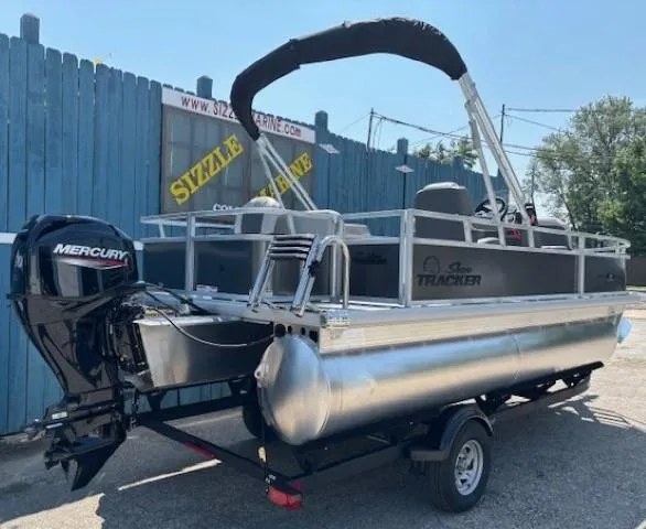 Slide: The Image of 2026 Sun Tracker Bass Buggy 18 DLX pontoon boat with Mercury engine, parked outdoors. - 3