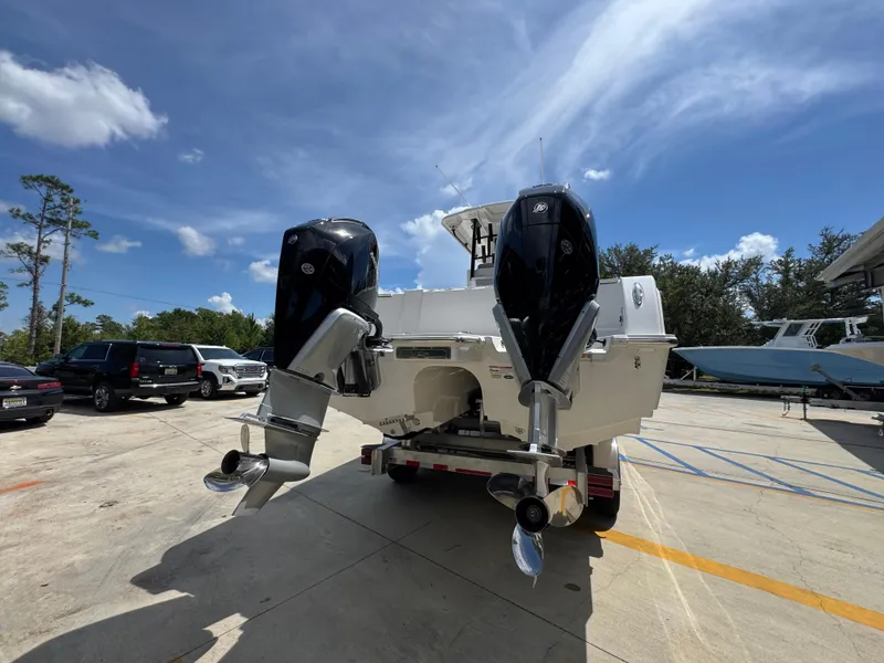 Slide: The Image of 2026 Caymas 30 CT boat with dual outboard motors in a parking lot. - 13