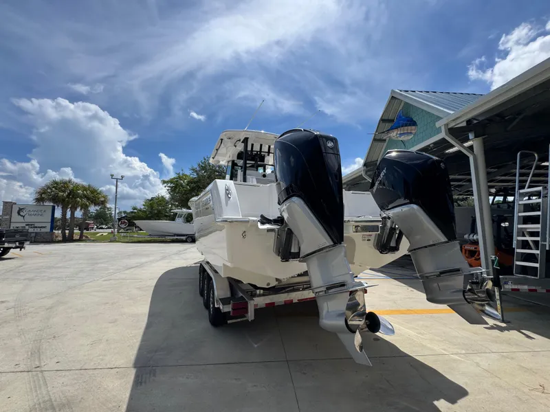 Slide: The Image of 2026 Caymas 30 CT boat with dual outboard motors in a marina setting under a blue sky. - 15
