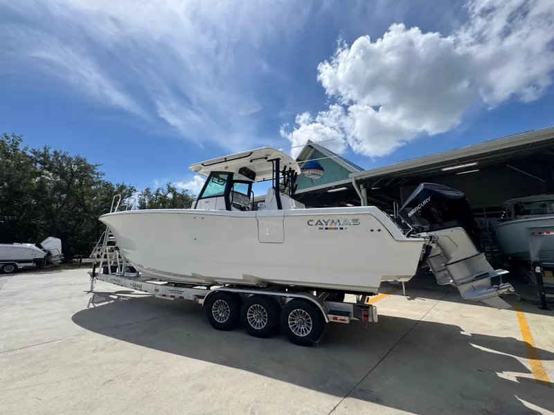 Slide: The Image of 2026 Caymas 30 CT boat on trailer under a sunny sky. - 17