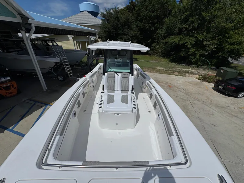 Slide: The Image of 2026 Caymas 30 CT boat with spacious deck and seating, parked outdoors. - 19
