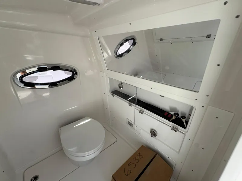 Slide: The Image of Interior of 2026 Caymas 30 CT boat bathroom with toilet and storage compartments. - 27