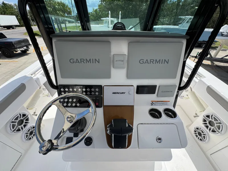 Slide: The Image of 2026 Caymas 30 CT boat dashboard with Garmin displays and Mercury controls. - 32