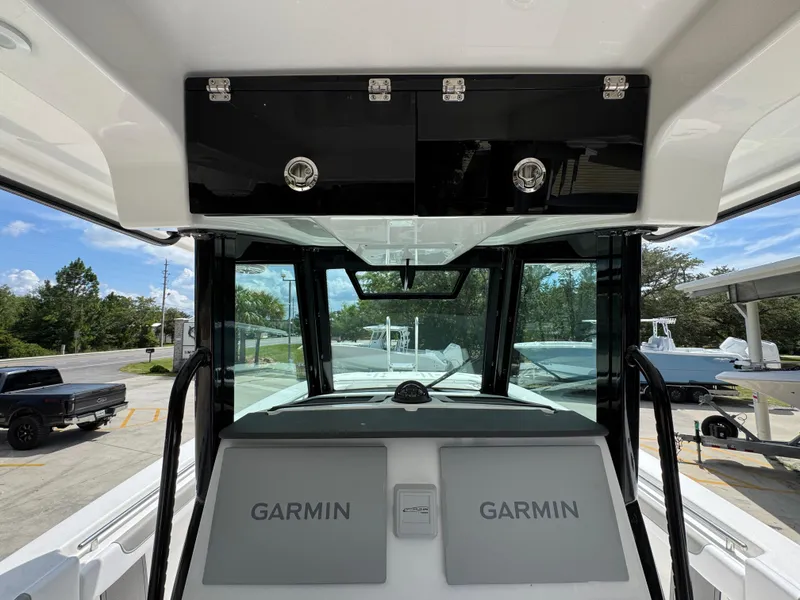 Slide: The Image of 2026 Caymas 30 CT boat interior with Garmin navigation displays and storage compartments. - 33