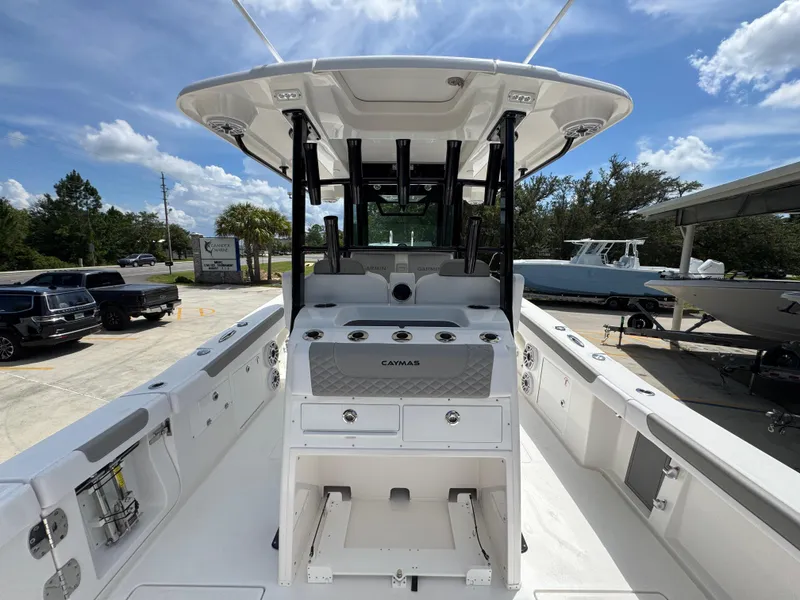 Slide: The Image of 2026 Caymas 30 CT boat interior with modern console and seating, parked outdoors. - 37