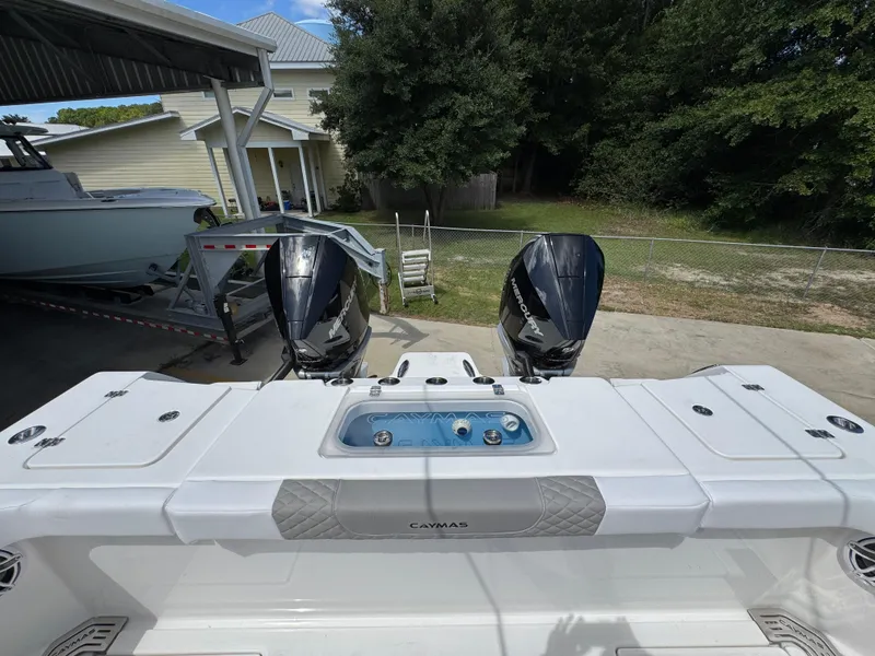 Slide: The Image of 2026 Caymas 30 CT boat with dual Mercury engines, parked outdoors. - 39