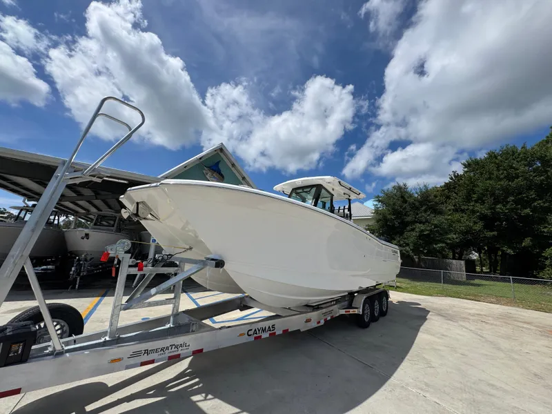 Slide: The Image of 2026 Caymas 30 CT boat on trailer under a bright blue sky. - 4