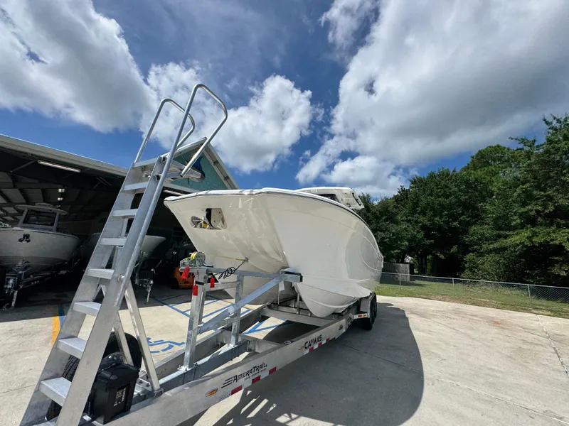 Slide: The Image of 2026 Caymas 30 CT boat on trailer under a partly cloudy sky. - 5