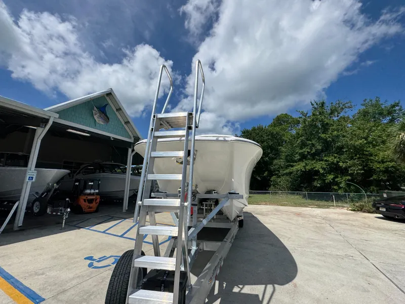 Slide: The Image of 2026 Caymas 30 CT boat on trailer under cloudy sky, near a building. - 6