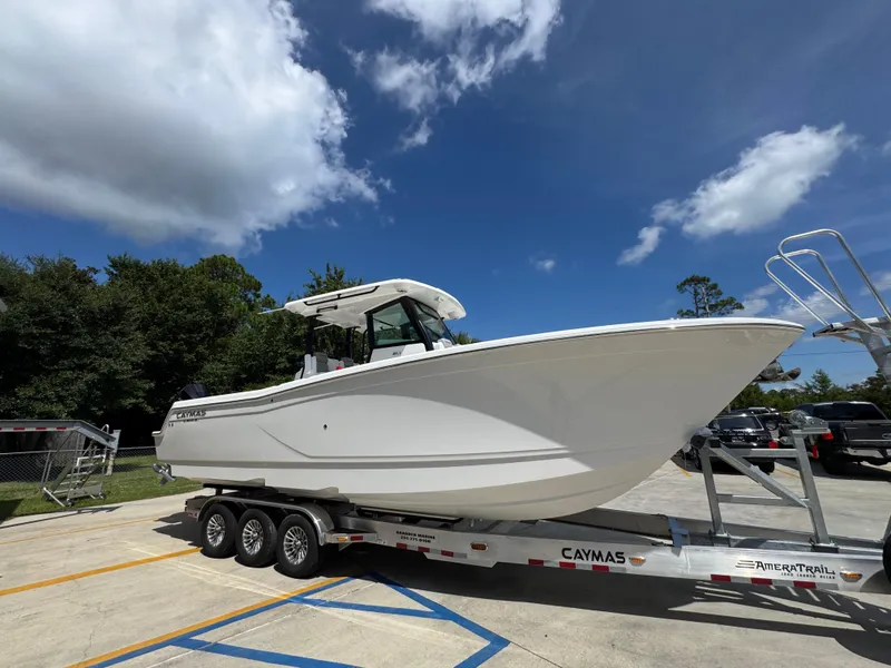 Slide: The Image of 2026 Caymas 30 CT boat on trailer under blue sky with clouds. - 9
