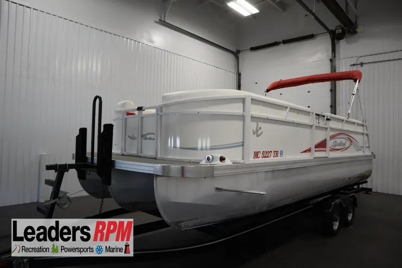 Slide: The Image of 2014 JC 22 Limited pontoon boat with red canopy in indoor storage. - 0