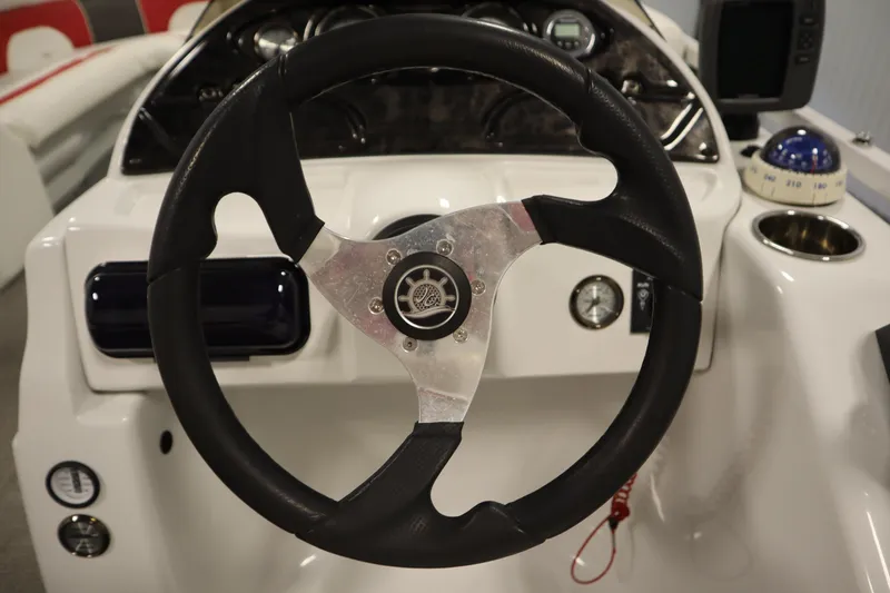 Slide: The Image of Steering wheel of 2014 JC 22 Limited boat with dashboard controls and compass. - 24