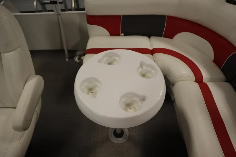 Slide: The Image of Interior of a 2014 JC 22 Limited boat with white and red seating and a round table. - 44