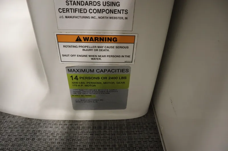 Slide: The Image of Warning label on JC 22 Limited 2014 boat, indicating maximum capacity and safety instructions. - 35